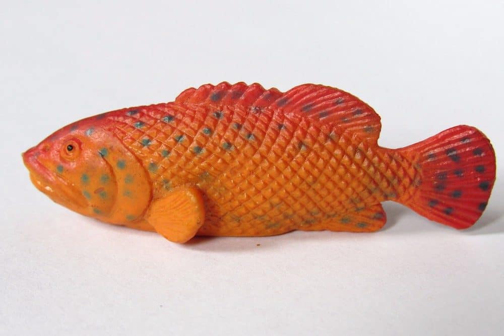 A Single Orange Toy Fish with Black Spots