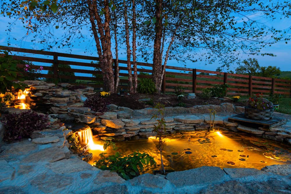 A Photo of a Koi Pond with Waterfalls at Night