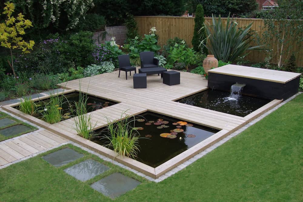 A Modern Koi Pond with a Wooden Terrace and Waterfalls